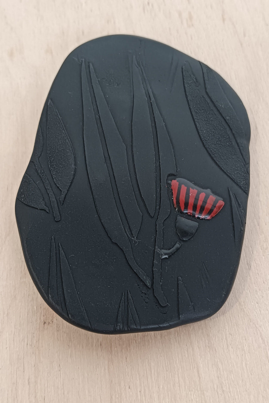 Black Polymer Clay with gum leaf imprint with red flower highlights